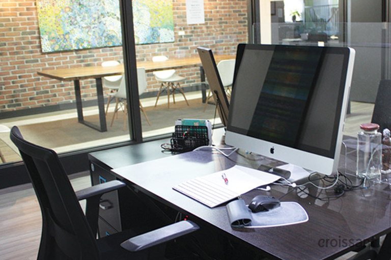 a desk with a laptop computer sitting on top of a table