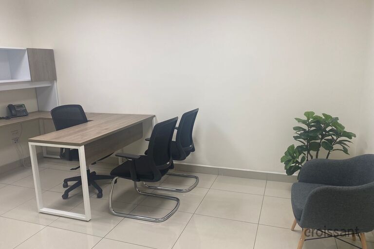 a desk with a computer and a chair in a room