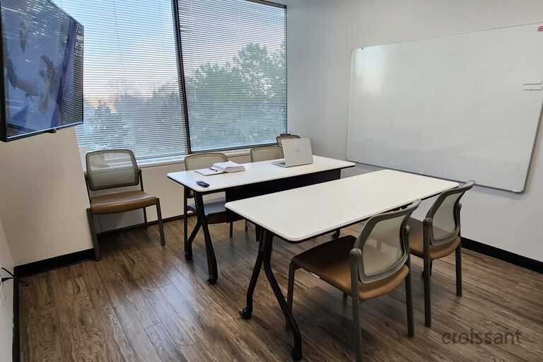 a bedroom with a bed and desk in a room