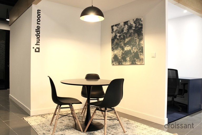a living area with a desk and chair in a room