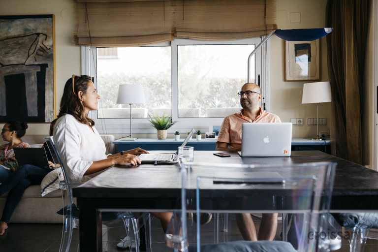 a group of people sitting at a table in a kitchen