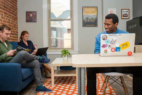 a man sitting at a table using a laptop