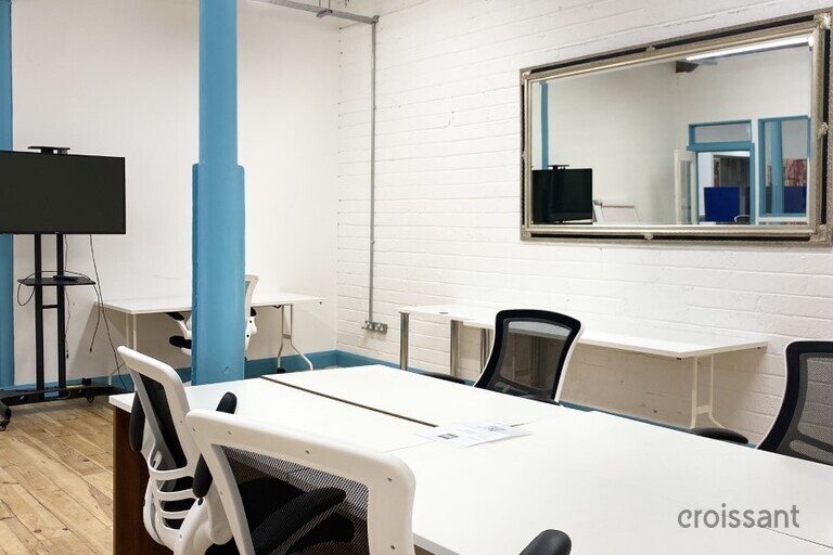 a bedroom with a bed and desk in a room