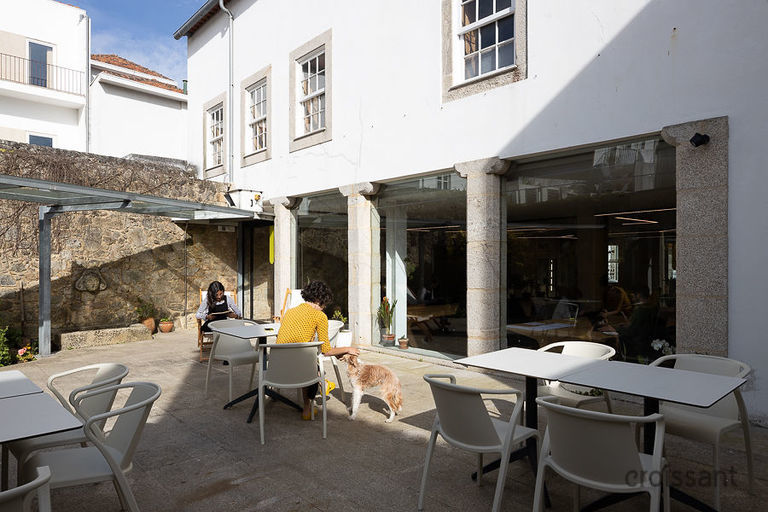 a group of people sitting at a table in front of a building