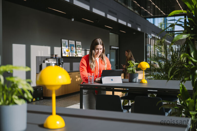 a person sitting at a table with a vase of flowers