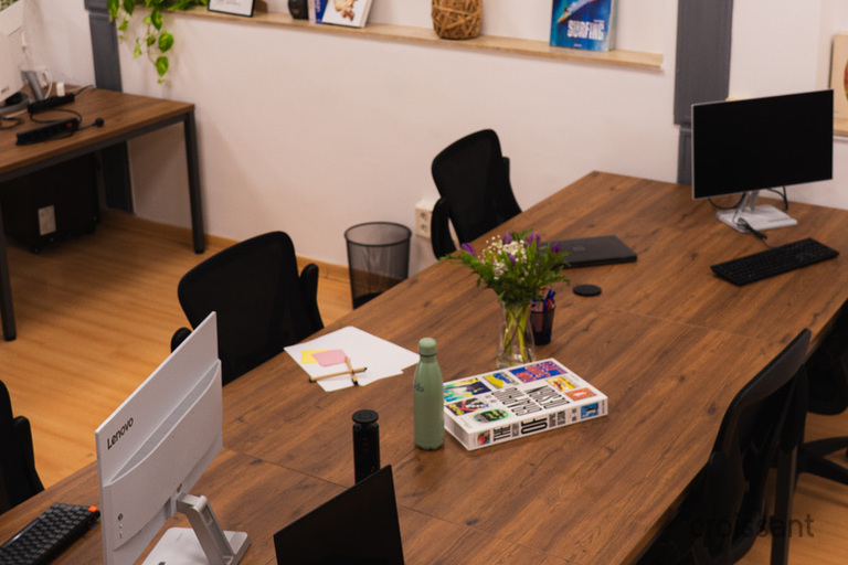 a desk with a laptop computer sitting on top of a wooden table