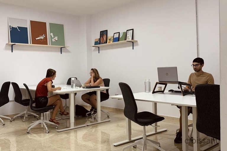 a group of people sitting at a desk and chair in a room