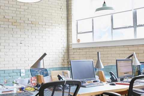 a desk with a computer and a chair in a room