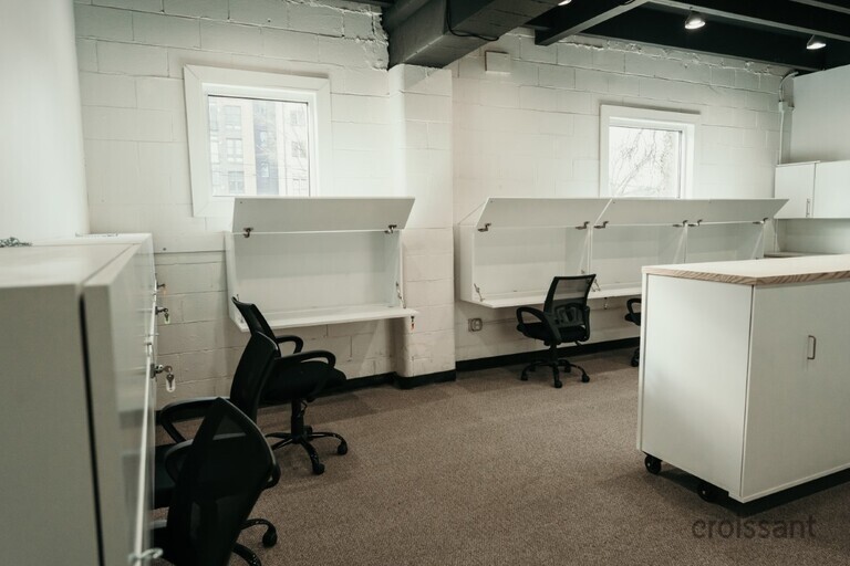a person sitting at a desk in a small room