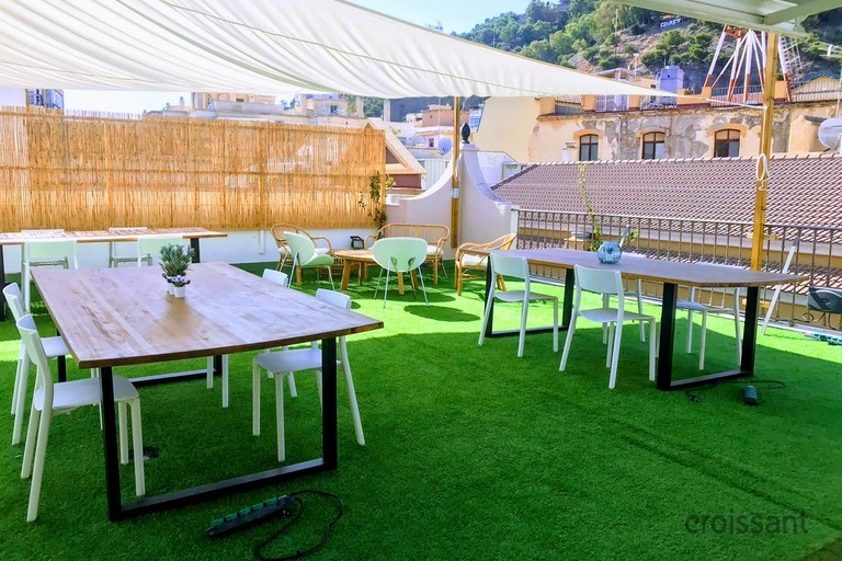 a group of people sitting at a table in front of a fence