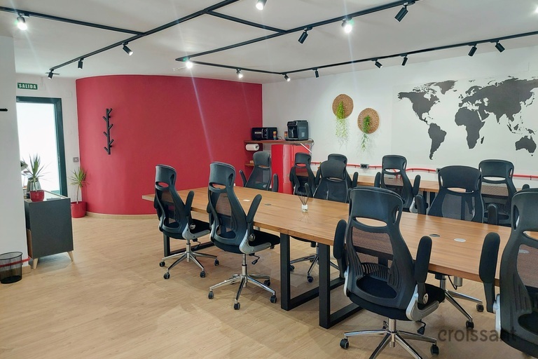 a desk with a computer and a chair in a room
