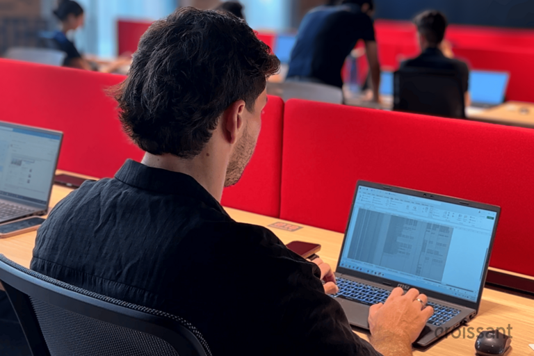 a man sitting at a table using a laptop computer
