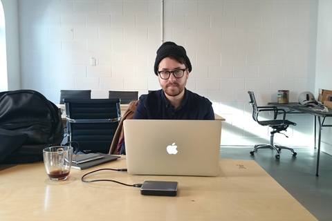a person sitting at a table using a laptop computer