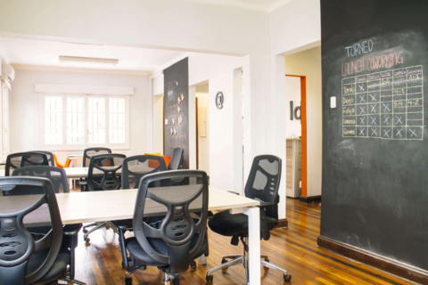 a desk with a computer and a chair in a room