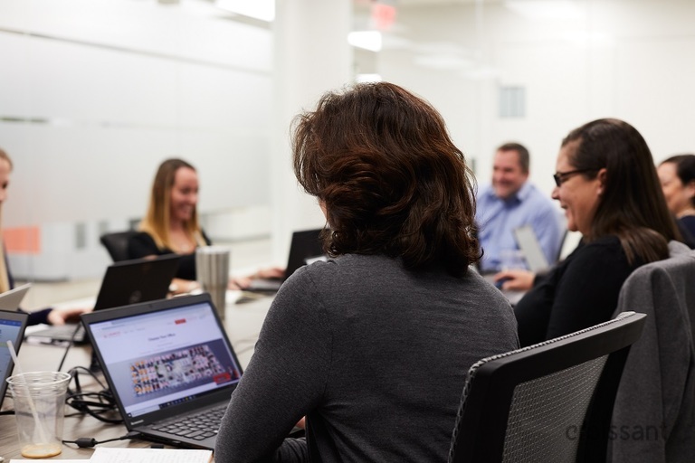 a group of people looking at a laptop