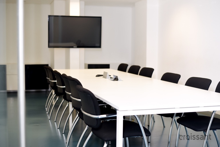 a desk with a computer and a chair in a room