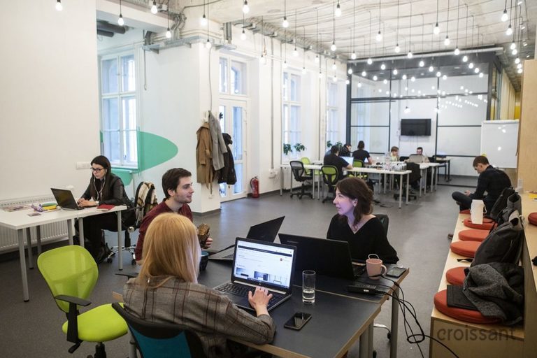 a group of people sitting at a desk with a laptop