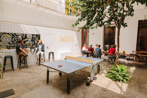 a group of people sitting at a table in front of a building