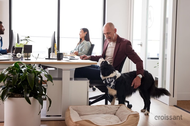 a man and a woman sitting at a table with a dog