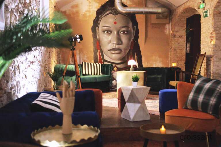 a person sitting at a table with a vase of flowers