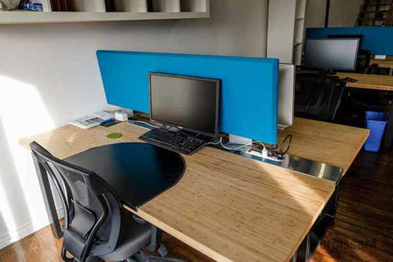 a desk with a laptop computer sitting on top of a wooden table