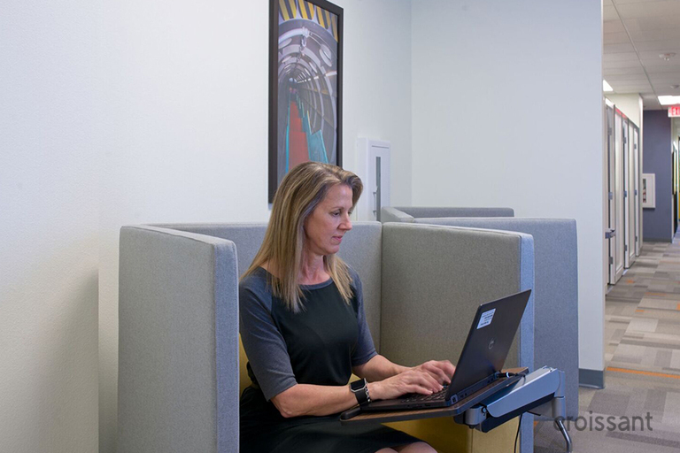 a person sitting at a table using a laptop computer