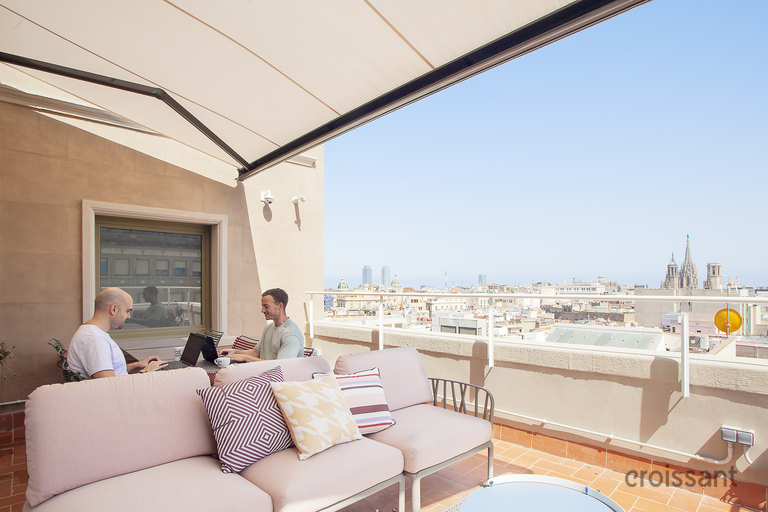 a group of people sitting at a table in front of a building
