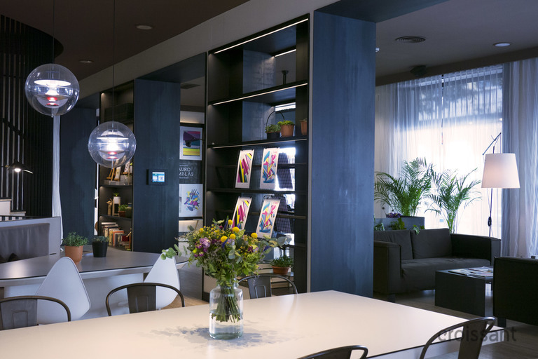 a living room filled with furniture and vase of flowers on a table