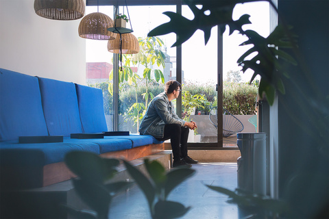 a person sitting at a table with a vase of flowers