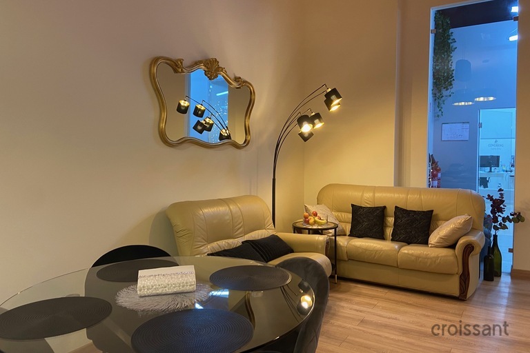 a living room with a couch a table and looking at the camera