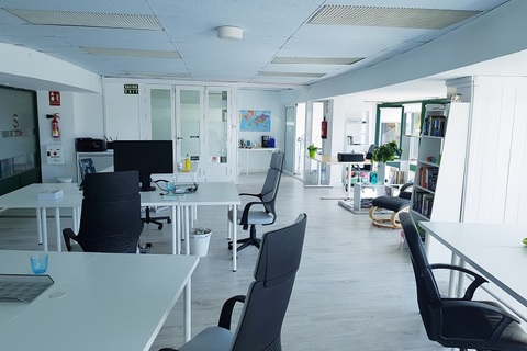 a desk with a computer and a chair in a room