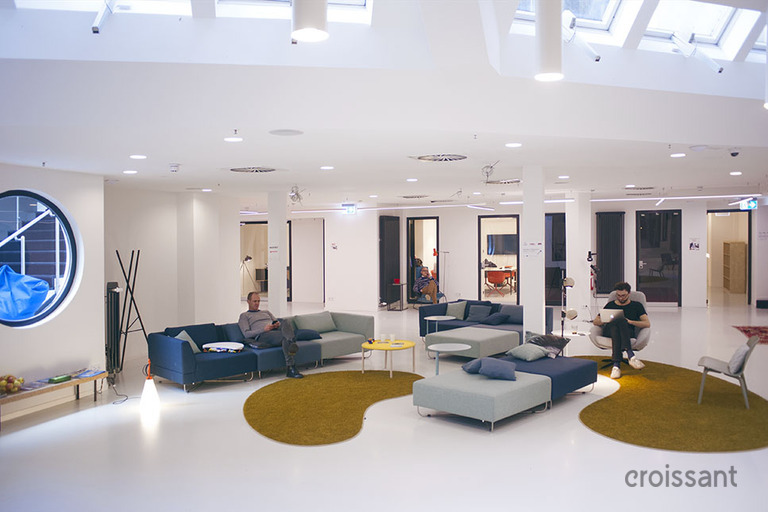 a living room filled with furniture and a large screen