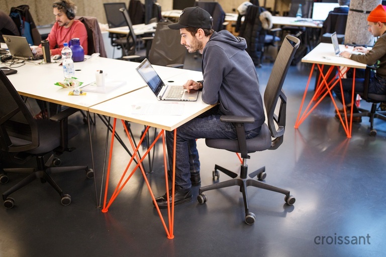 a group of people sitting at a table using a laptop