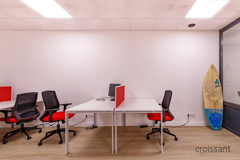 a desk with a computer and a chair in a room