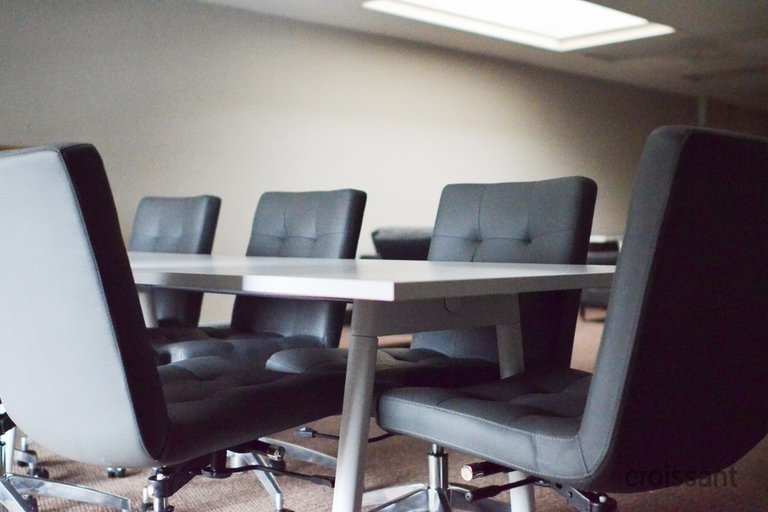 a desk with a computer and a chair in a room