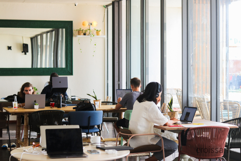 a group of people sitting at a desk in front of a window