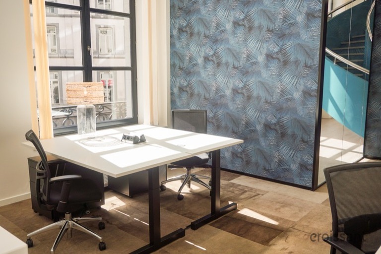 a desk with a computer and a chair in a room