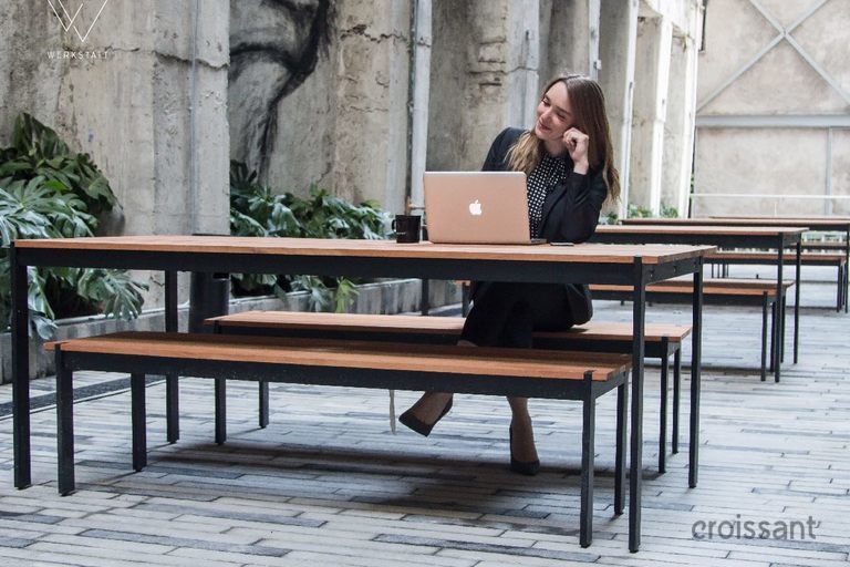 a person sitting on a bench in front of a building