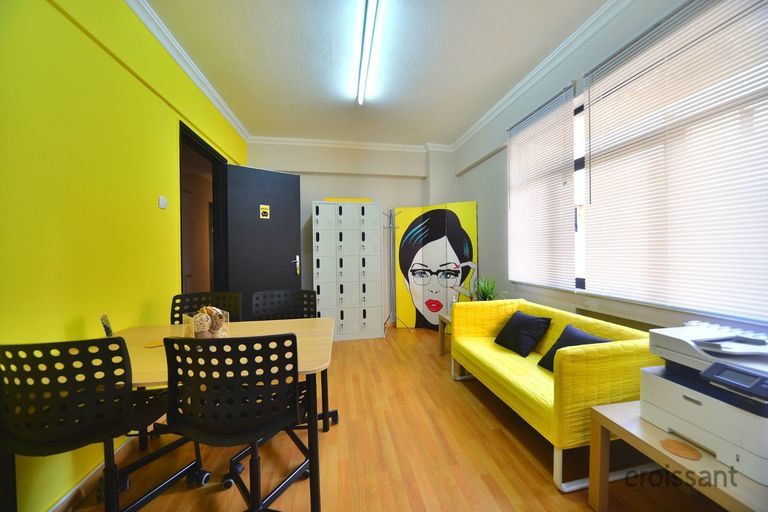 a desk with a computer and a chair in a room