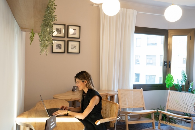 a woman sitting at a table using a laptop